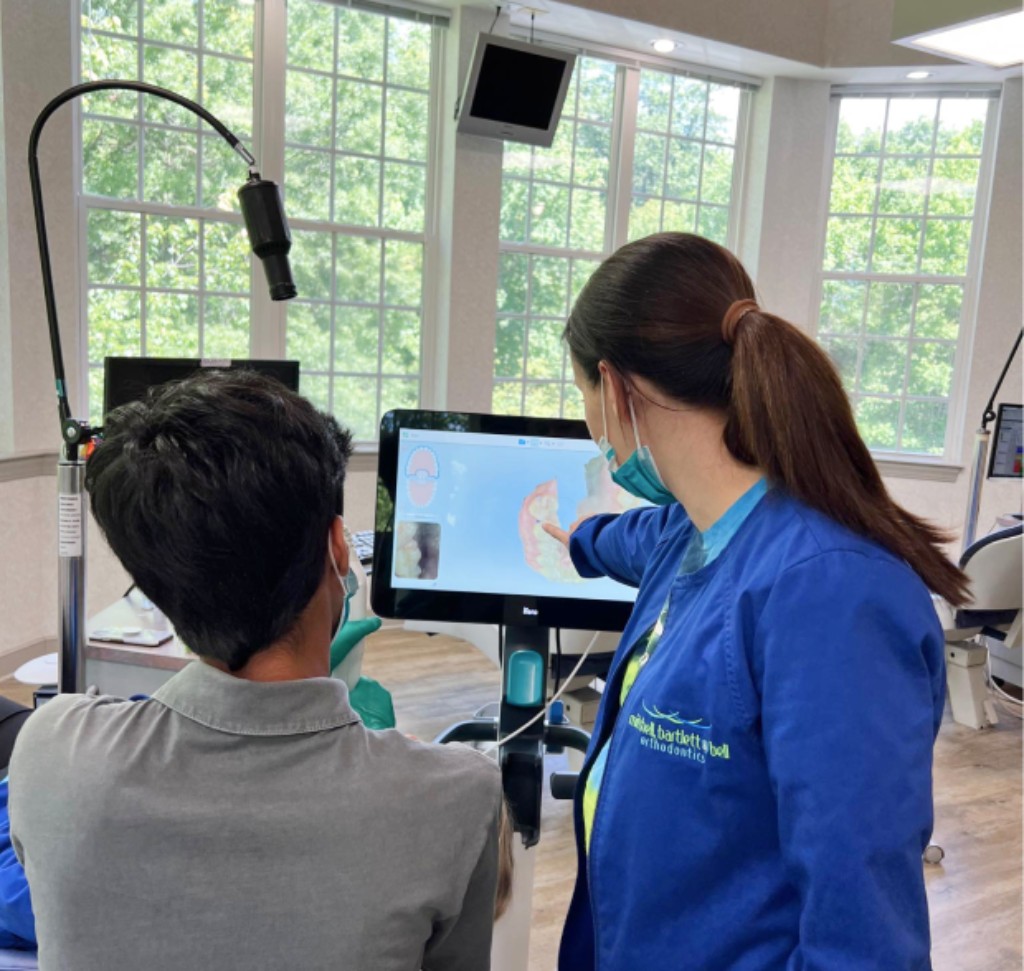 Mitchell, Bartlett & Bell Orthodontics doctor showing braces to patient